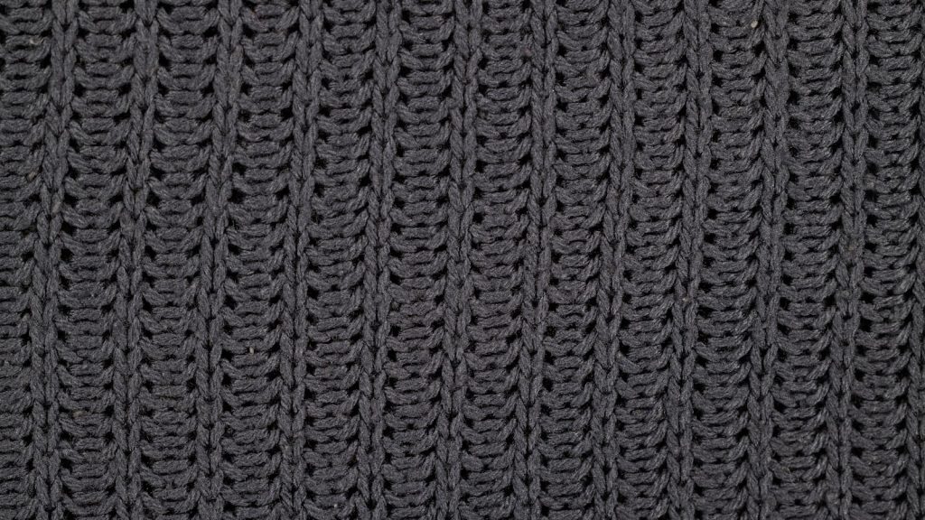 Maille côtelée gris foncé vue de près, texture d'un tricot épais