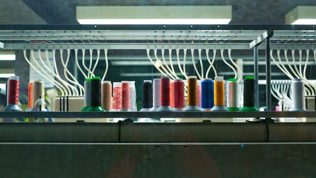 Rampe de cônes et guide-fils d'une machine à broder, les fils courant dans leurs tubes